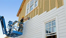 Construction crew member working on outside of a new home.